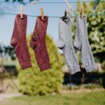 Vibrant socks hanging on a clothesline under a sunny sky, showcasing everyday life and hygiene.