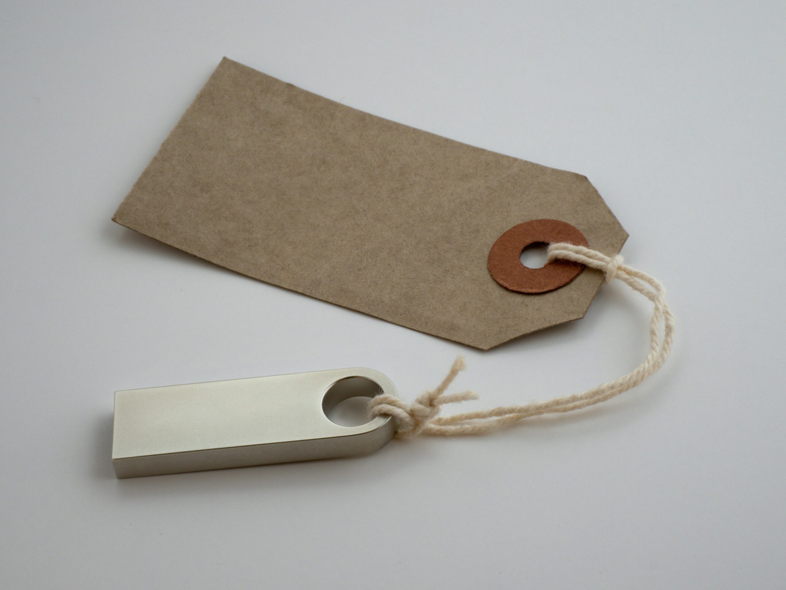 A minimalist paper tag with twine string on a neutral background, ideal for product labeling.